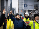 Protesters give peace signs in solidarity at a rally against COVID-19 restrictions outside the parliament buildings in Ottawa, Feb. 17, 2022.