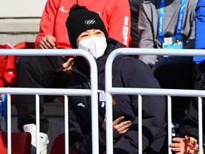 China's Peng Shuai with IOC President Thomas Bach as they watch the event. China's Peng Shuai wearing a face mask watches the event.
