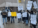 Eine Gruppe von Demonstranten vor dem Hauptquartier des Ottawa Police Service zeigt ihre Enttäuschung darüber, wie die Polizei mit dem Protest gegen das Impfmandat umgegangen ist, der den Innenstadtkern der Stadt erobert hat.