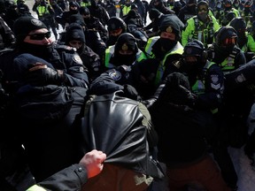 Die Polizei überwältigt und nimmt einen Demonstranten fest, während Trucker und Unterstützer am 18. Februar 2022 in Ottawa gegen Coronavirus-Impfstoffmandate protestieren.