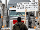 Ein Mann in Ottawa hält ein Schild, auf dem die Teilnehmer des Freiheitskonvois aufgefordert werden, am 2. Februar 2022 nach Hause zu gehen. Die Trucker sagen, dass sie nicht planen zu gehen.