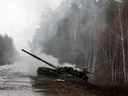   Rauch steigt aus einem russischen Panzer auf, der am 26. Februar 2022 am Rand einer Straße in der Region Lugansk von ukrainischen Streitkräften zerstört wurde.
