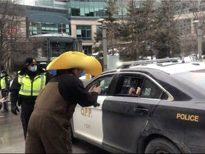 At 1 p.m. Thursday outside of the World Exchange Plaza in downtown Ottawa, a man shot a video appearing to show an OPP officer allowing people in the back of a marked cruiser to take pictures.