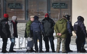 Die Polizei bereitet sich darauf vor, Häftlinge – einige von ihnen an den Handgelenken gefesselt – von der Besatzungsstelle des Konvois wegzubringen, während sie damit beginnt, einen von Lastwagenfahrern organisierten Protest gegen Impfaufträge am 18. Februar 2022 in Ottawa aufzulösen