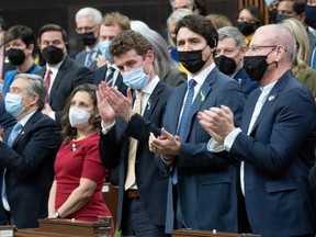 Canadian Prime Minister Justin Trudeau (C) applauds with members of parliament following a virtual address by Ukrainian President Volodymyr Zelensky on March 15, 2022, in Ottawa.
