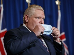 Der Premierminister von Ontario, Doug Ford, hier zu sehen, wie er nach einer Pressekonferenz im Dezember im Queen's Park in Toronto seine Maske wieder aufsetzt.