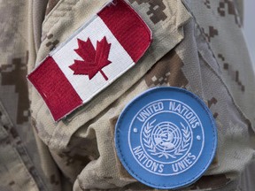 Canadian flag and the UN flag is shown on the sleeve of a Canadian soldier's uniform before boarding a plane at CFB Trenton in Trenton, Ont., on July 5, 2018. THE CANADIAN PRESS/Lars Hagberg