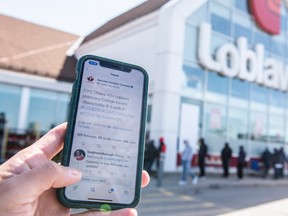 A post from Twitter account Vaccine Hunters Canada that shared details of a walk-in COVID-19 vaccination clinic at a Loblaws pharmacy in Ottawa is seen on a mobile phone as people line up outside the store, on April 26, 2021.