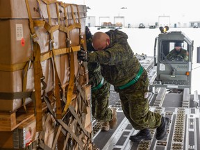 Members of the Canadian Armed Forces load military equipment bound for Ukraine onto a CC-177 Globemaster at CFB Trenton.