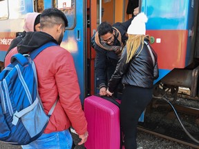 A Ukrainian refugee woman is helped by an Indian student at the railway station in Zahonyi, close to the Hungarian-Ukrainian border, on March 1.