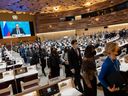 Diplomaten gehen, während Russlands Außenminister Sergej Lawrow heute auf der 49. Sitzung des UN-Menschenrechtsrates in seinem europäischen Hauptquartier in Genf mit einer vorab aufgezeichneten Videoansprache auf dem Bildschirm zu sehen ist. 