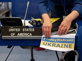 A member of the US delegation to IAEA (International Atomic Energy Agency) fixes a sign reading "today we are all Ukraine" ahead of a meeting of the IAEA Board of Governors at the IAEA headquarters in Vienna, Austria on March 02, 2022.