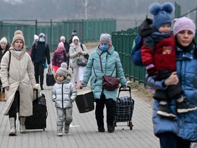 Frauen mit ihren Kindern überqueren am 8. März 2022 am Grenzübergang Medyka die ukrainische Grenze nach Polen.