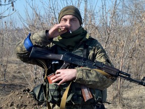 A serviceman of Ukrainian military forces smokes a cigarette at a checkpoint, where they hold a position near Kharkiv on March 23, 2022.