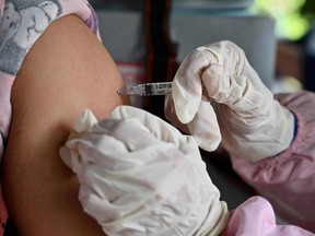 In this file photo taken on March 29, 2022 a nurse administers a Pfizer booster vaccine for the Covid-19 coronavirus in Jakarta on March 29, 2022. - The United States March 29, 2022 authorized a fourth dose of either the Pfizer-BioNTech or Moderna Covid-19 vaccines for people 50 and older, as authorities warn of a possible new wave driven by the BA.2 variant. (Photo by ADEK BERRY / AFP) (Photo by ADEK BERRY/AFP via Getty Images)