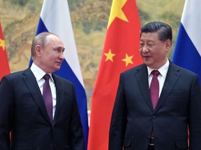 Russian President Vladimir Putin (L) and Chinese President Xi Jinping pose for a photograph during their meeting in Beijing, on February 4, 2022.