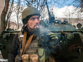 A volunteer of the Ukrainian Territorial Defense Forces stands next to his APC in Kharkiv, Ukraine, Wednesday, March 16, 2022.