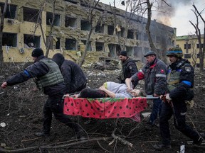 Ukrainian emergency employees and volunteers carry an injured pregnant woman from the damaged by shelling maternity hospital in Mariupol, Ukraine, Wednesday, March 9, 2022. A Russian attack has severely damaged a maternity hospital in the besieged port city of Mariupol, Ukrainian officials say.