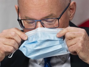 Dr. Kieran Moore, Ontario's chief medical officer of health places his mask on as holds a press conference regarding the lifting of most mask mandates for indoor settings in Ontario, on March 9, 2022.