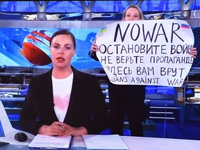 A woman later identified as Marina Ovsyannikova, an employee of Russia’s state broadcaster Channel One, interrupts a news broadcast on March 15, 2022, with an anti-war message.