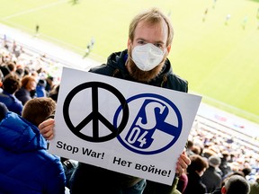 A Schalke 04 fan holds a sign to indicate sympathy with Ukraine during a match on Feb. 26, 2022, in Karlsruhe, Germany. The German soccer club has cancelled its partnership with Russia's state-owned energy giant, Gazprom, and dropped the Gazprom logo from team jerseys, as Europe distances itself from Russia in the wake of Russia's invasion of Ukraine.