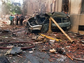 Police and rescue workers stand near destroyed cars and debris on March 17, 1992, in Buenos Aires, shortly after a powerful bomb ripped through the Israeli Embassy, virtually destroying the five-story building and killing 29 people.