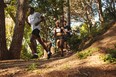 Athletes running down hill on mountain trail. Men and women runner running in a cross country marathon race.