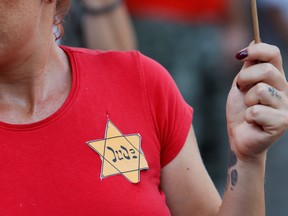 A protester wears a Star of David badge with the German word "Jude" (Jew) at a demonstration against COVID-19 measures.