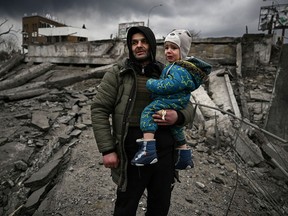 A man holds a child as he flees the city of Irpin, west of Kyiv, on March 7, 2022, as Russian forces pummelled Ukrainian cities from the air, land and sea.