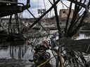 Verlassene Spaziergänger sind unter einer zerstörten Brücke abgebildet, als Menschen am 7. März 2022 aus der Stadt Irpin westlich von Kiew fliehen. – Russische Streitkräfte haben am Montag ukrainische Städte aus der Luft, zu Land und zu Wasser mit Warnungen geschlagen, dass sie sich auf einen Angriff vorbereiten würden in der Hauptstadt Kiew, als verängstigte Zivilisten einen zweiten Tag lang nicht aus dem belagerten Mariupol fliehen konnten. 
