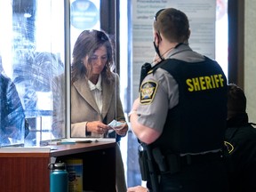Lisa Banfield, spouse of Gabriel Wortman, puts on a facemask at Nova Scotia Provincial court in Dartmouth on Wednesday, March 9, 2022. Banfield's lawyer withdrew her not guilty plea to charges related to illegally transferring ammunition to Wortman, responsible for the mass murders in rural Nova Scotia in April 2020.  THE CANADIAN PRESS/Andrew Vaughan