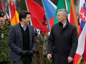 NATO Secretary-General Jens Stoltenberg and Canadian Prime Minister Justin Trudeau interact as they arrive in Adazi, Latvia on March 8, 2022.