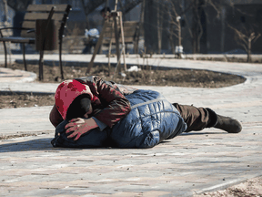 A mother covers her son as they lay on a ground after hearing shelling during the Ukraine-Russia conflict in the besieged southern port of Mariupol, Ukraine, March 23, 2022.