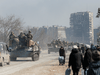 Pro-Russian troops drive armoured vehicles past local residents during the Ukraine-Russia conflict in the besieged southern port city of Mariupol, Ukraine, on March 24, 2022.