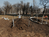 Graves of residents killed by shelling during the Ukraine-Russia conflict are seen in a yard in the besieged southern port of Mariupol, Ukraine, March 23, 2022.