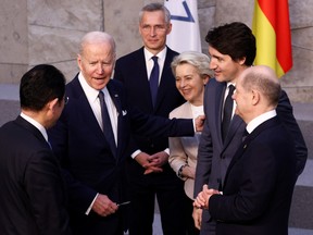 U.S. President Joe Biden speaks with Japan's Prime Minister Fumio Kishida, Germany's Chancellor Olaf Scholz, Canada's Prime Minister Justin Trudeau, European Commission President Ursula von der Leyen and NATO Secretary General Jens Stoltenberg before a G7 leaders' family photo during a NATO summit on Russia's invasion of Ukraine, at the alliance's headquarters in Brussels, Belgium March 24, 2022. REUTERS/Henry Nicholls/Pool