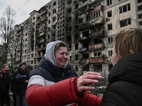 A woman cries outside destroyed apartment buildings following Russian shelling on the northwestern Obolon district of Kyiv, Ukraine, on March 14, 2022.