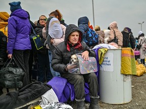 Ein Mann sitzt mit seinem kleinen Hund auf dem Schoß im Aufnahmezentrum in Medyka an der polnisch-ukrainischen Grenze.  (Foto: Milos Bicanski/We Animals Media)