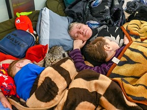 Eine verängstigte Katze späht aus der Pritsche am Krakauer Bahnhof in Polen, wo eine Familie ukrainischer Flüchtlinge für eine dringend benötigte Ruhepause angehalten hat, nachdem sie nur mit dem, was sie tragen konnten, aus ihrer Heimat geflohen ist.  Der Bahnhof wurde in eine provisorische Unterkunft für ankommende Flüchtlinge aus der russischen Invasion in der Ukraine umgewandelt, die Essen, einen warmen Ort zum Ausruhen, Informationen und kostenlose Zugfahrkarten nach ganz Polen bieten.  (Foto: Milos Bicanski/We Animals Media)