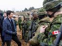 Prime Minister Justin Trudeau talks with NATO troops, including Canadian troops, during a visit to the Adazi military base northeast of Riga, Latvia, on March 8.