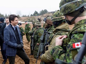 Prime Minister Justin Trudeau talks with NATO troops, including Canadian soldiers, during a visit to the Adazi military base, northeast of Riga, Latvia, on March 8.