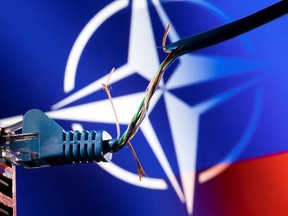 Broken Ethernet cable is seen in front of NATO logo and Russia flag colors in this illustration taken March 8, 2022. REUTERS/Dado Ruvic/Illustration