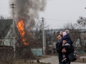 Anwohner fliehen aus der Stadt Irpin, nachdem schwerer Beschuss auf dem einzigen Fluchtweg der Einheimischen gelandet war, als russische Truppen am 6. März 2022 in Richtung der Hauptstadt Kiew in Irpin bei Kiew, Ukraine, vorrücken.