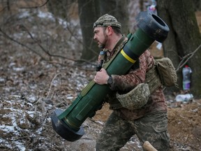 Ein ukrainisches Militärmitglied geht am 13. März 2022 mit einem Javelin-Raketensystem an der Front in der Region Nord-Kiew, Ukraine, in Position.