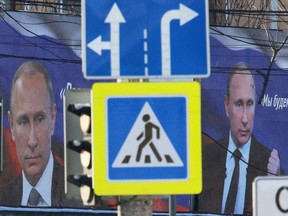 FILE PHOTO: Boards with portraits of Russian President Vladimir Putin are seen on a street in Simferopol, Crimea March 11, 2022. REUTERS/Alexey Pavlishak/File Photo