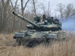 Service members of the Ukrainian armed forces are seen atop of a tank at their positions outside the settlement of Makariv, amid the Russian invasion of Ukraine, on March 4.
