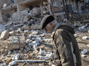 A man walks through debris in front of a residential apartment complex that was heavily damaged by a Russian attack in Kyiv, Ukraine, on March 18, 2022.