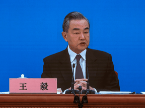 China's Foreign Minister Wang Yi is seen on a video screen as he holds a news conference in Beijing on March 7, 2022.