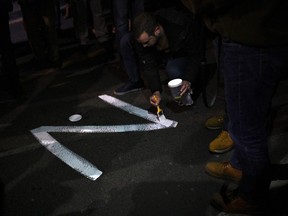 A protester paints the "Z" sign on a street, in reference to Russian tanks marked with the letter, during a rally organised by Serbian right-wing organisations in support of Russian invasion in Ukraine, in Belgrade March 4, 2022.