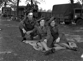 Drei Mitglieder der kanadischen Streitkräfte, kurz nach dem Ende des Zweiten Weltkriegs in den Niederlanden abgebildet.  Die beiden Rechten durften nicht in den Krieg ziehen, es sei denn, sie trugen Nylons und Absätze.